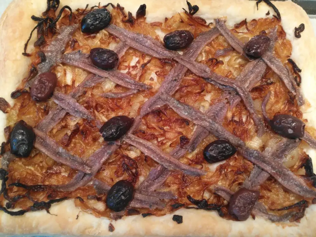 Southern France appetizer with puff pastry, caramelized onions, anchovies and black olives
