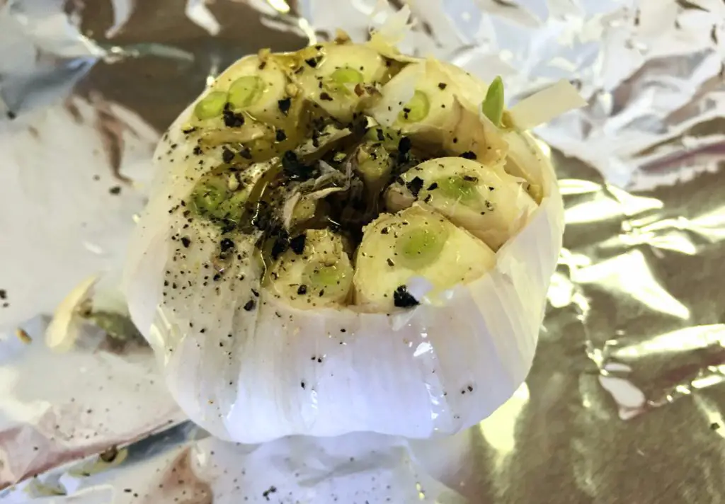 Old head of garlic seasoned with salt and pepper for roasted garlic