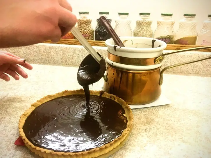 pouring ganache into the tart shell