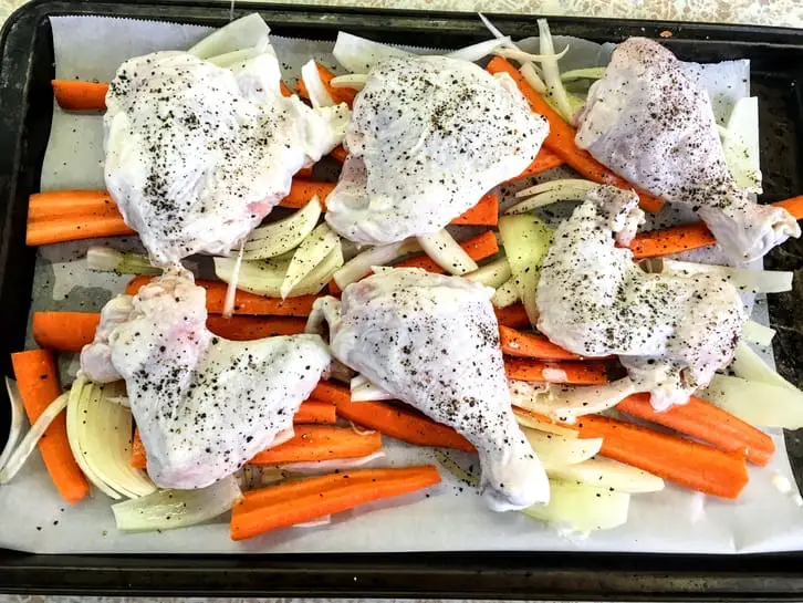 kefir-brined chicken on top of carrots and onions