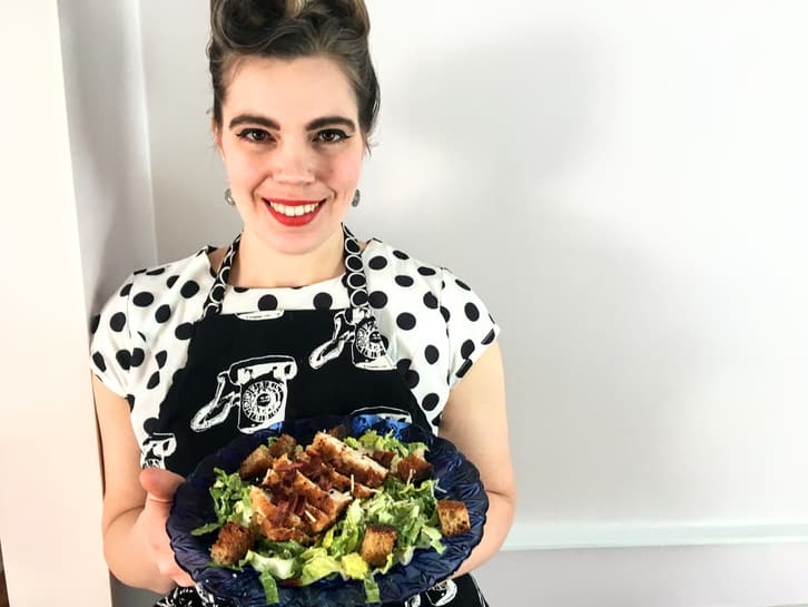 presenting a plate of pan-fried chicken caesar salad