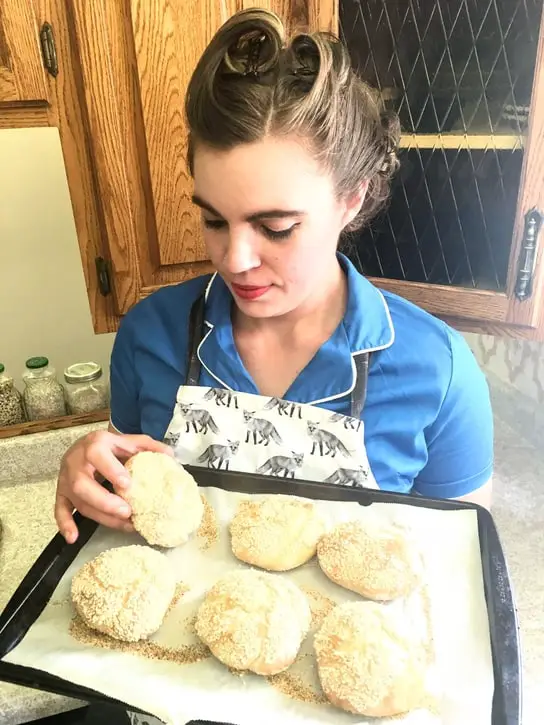 holding a tray of fresh kaiser rolls